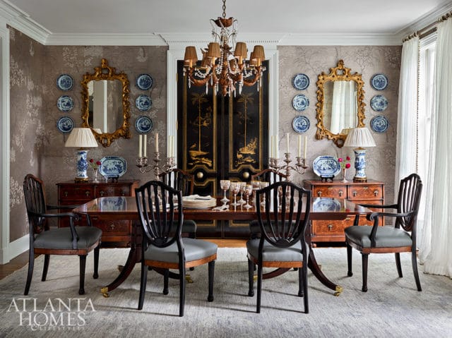 Dining room with dark wood table, upholstered chairs, ornate mirrors, and chinoiserie screen.