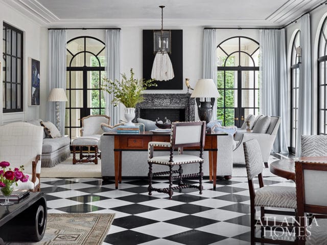 Living room with black and white checkered floor, arched windows, fireplace, and ornate furniture