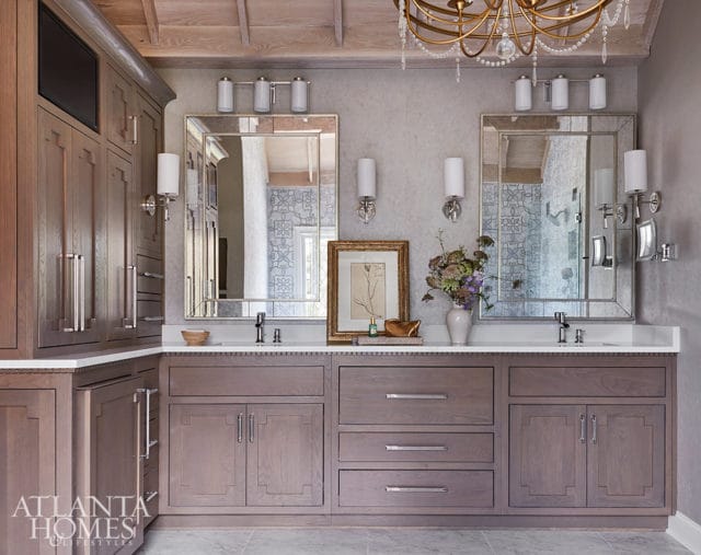 Gray wood vanity with marble countertop, two mirrors, and wall sconces.
