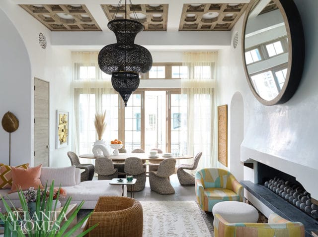 Living and dining room with white walls, ornate ceiling, black lantern chandelier, and rattan