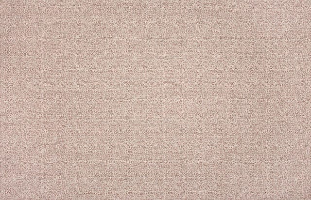 Close-up of a repeating geometric pattern in red and beige tones.