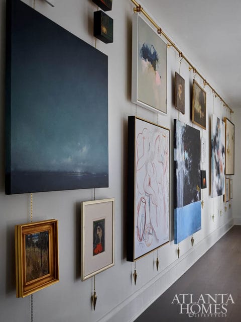 Hallway with a gallery wall of diverse artwork, including abstract and figurative pieces, displayed