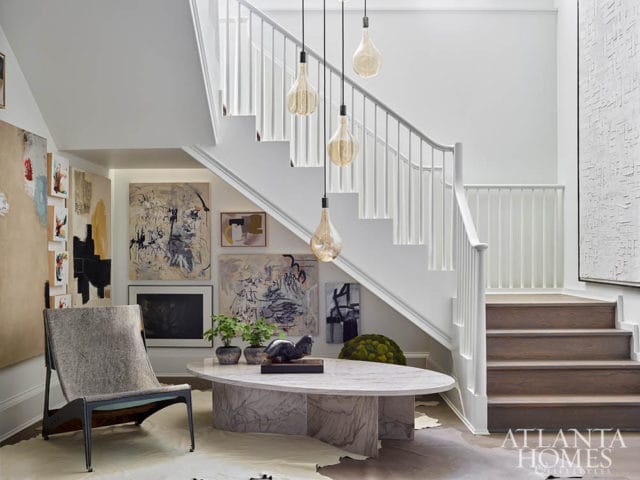 Modern staircase with abstract art, marble coffee table, and contemporary chair