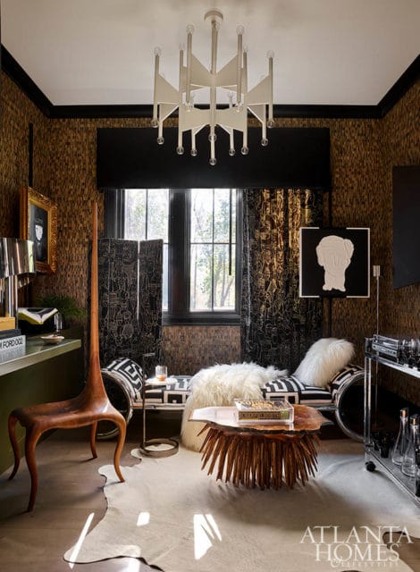 Living room with textured brown walls, black and white patterned sofa, and sculptural wood chair.