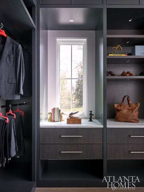 Dark wood closet with suits, shoes, and a woven tote bag.