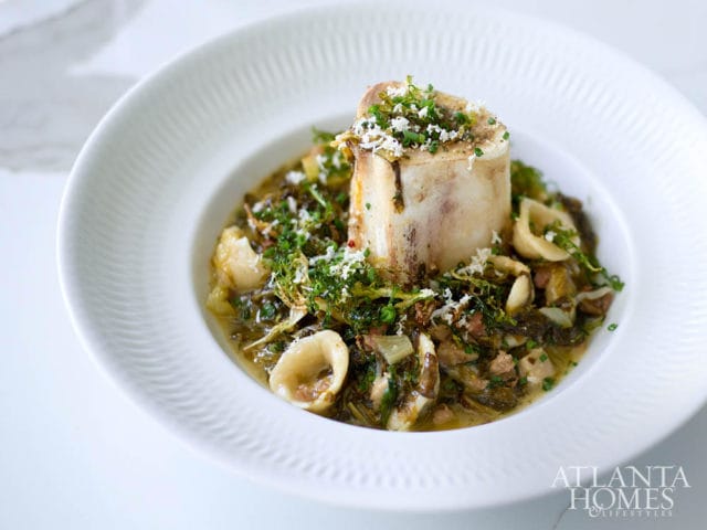 Bone marrow with pasta and greens, sprinkled with cheese and herbs.