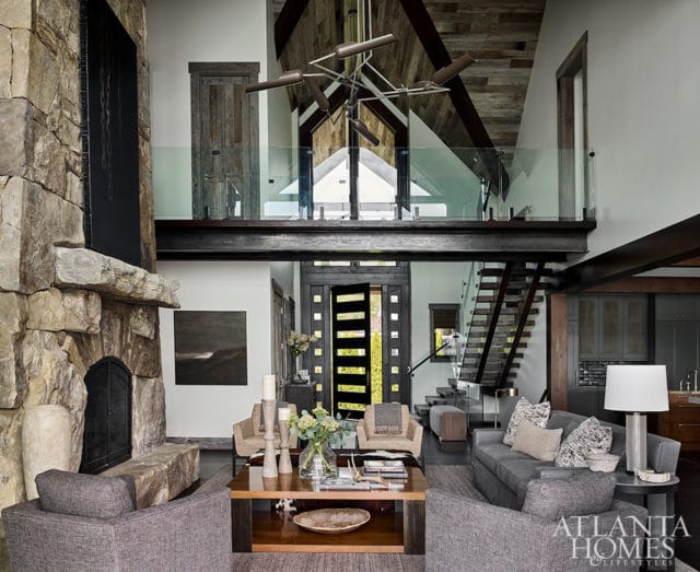 Living room with stone fireplace, gray sofas, and wood-paneled vaulted ceiling.