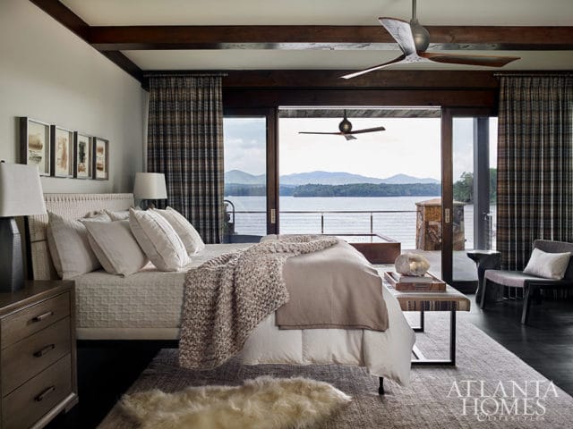 Bedroom with lake view, plaid curtains, white bedding, and wood ceiling beams