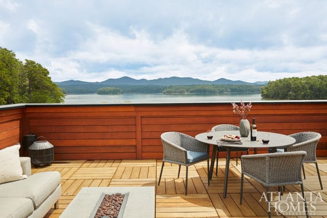 Deck with outdoor dining set overlooking a lake and mountains