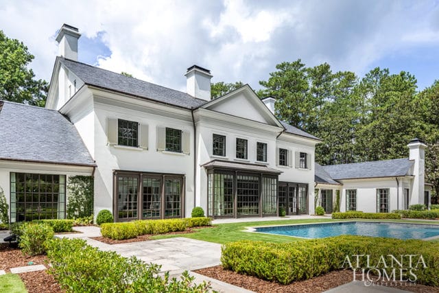 White modern home with dark-trimmed windows and a swimming pool