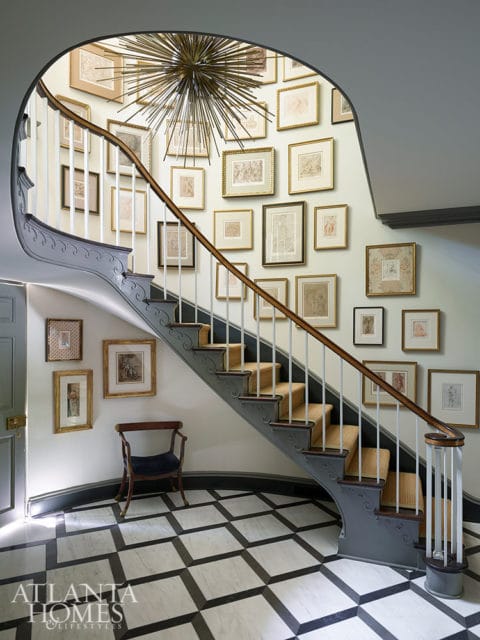 Entryway with curved staircase, gallery wall, and black and white marble floor