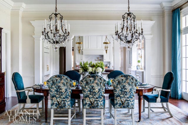 Dining room with dark wood table, blue velvet chairs, and floral upholstered chairs.