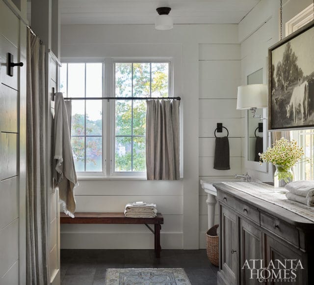 Farmhouse bathroom with shiplap walls, wooden bench, and vintage vanity