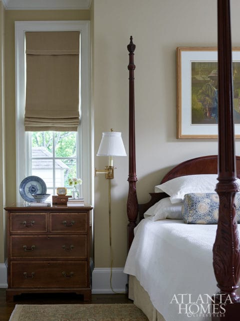 Bedroom with mahogany four-poster bed, white bedding, and antique dresser.