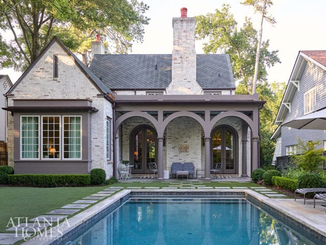 White brick house with arched covered patio and swimming pool