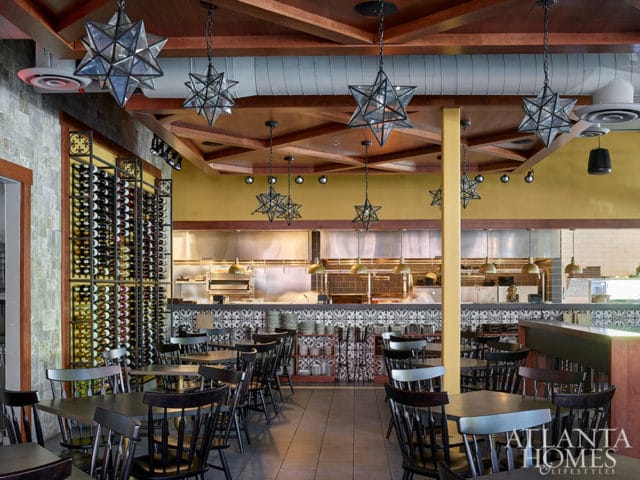 Restaurant dining area with star pendant lights, wine racks, and open kitchen