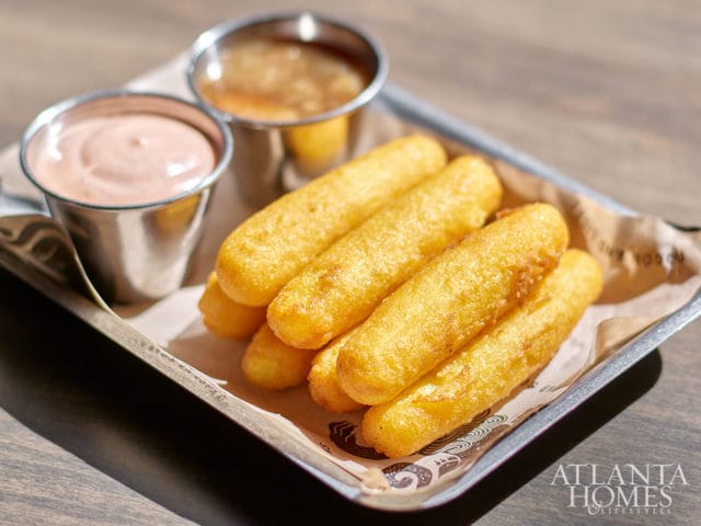 Fried cheese sticks with dipping sauces on a metal tray