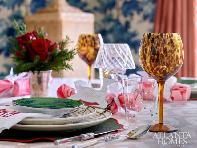 Table setting with floral plates, leopard print wine glass, and red roses