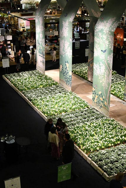 Hallway lined with white flowers and decorative pillars featuring floral and bird murals.