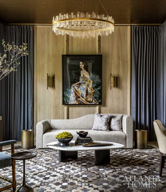Living room with gray sofa, marble coffee table, patterned rug, and artwork of a woman in a gown.