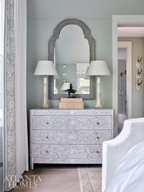 Gray dresser with mother-of-pearl inlay, arched mirror, and two lamps