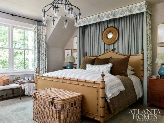 Bedroom with a bamboo-style bed, blue and white striped bedding, and patterned curtains.