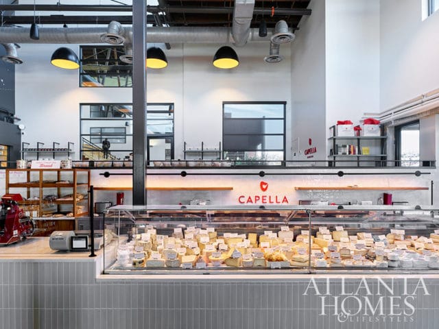 Capella cheese shop interior with display cases full of cheese, bread shelves, and industrial