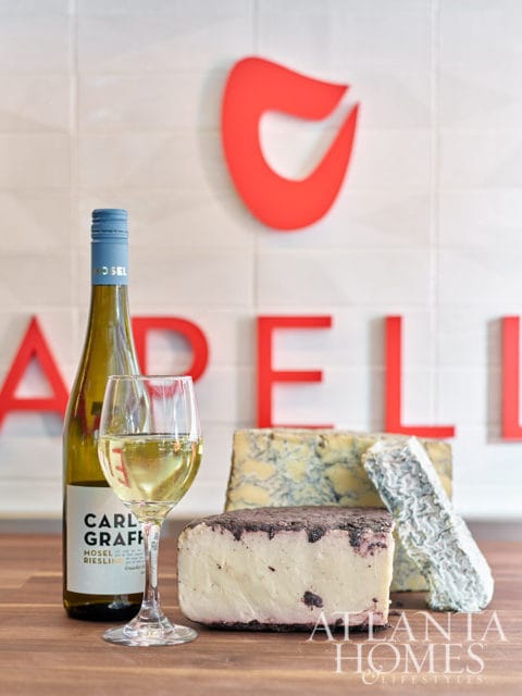 Bottle of Carl Graff Mosel Riesling wine, glass of wine, and three cheeses.
