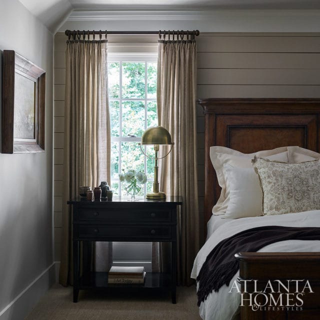 Bedroom with dark wood bed, black nightstand, and brass lamp.