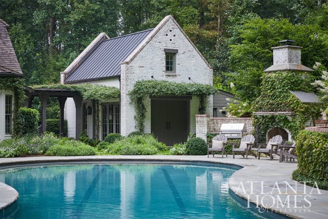 Atlanta Homes & Lifestyles magazine cover with pool, white brick building, and outdoor fireplace.