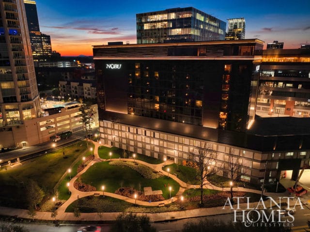 Nobu hotel at dusk with illuminated grounds and city skyline