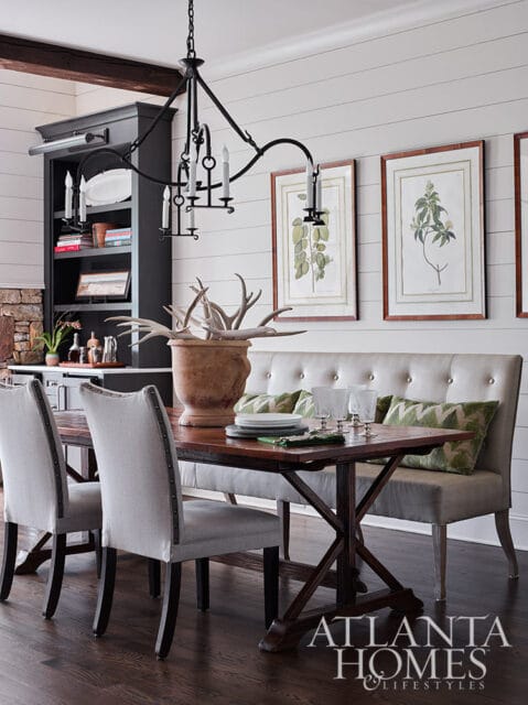 Dining room with tufted banquette, wood table, and upholstered chairs.