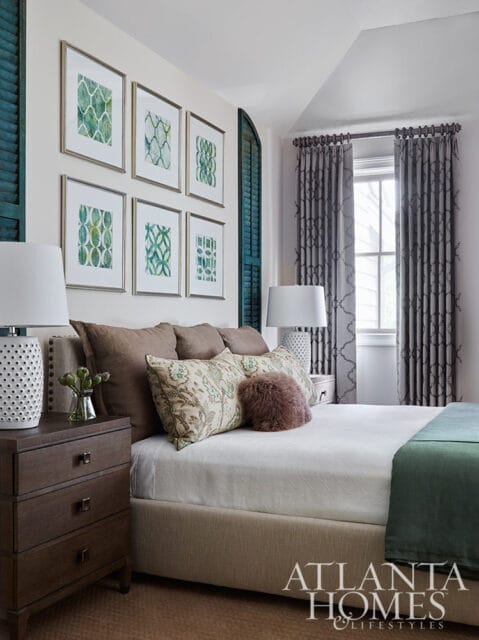 Bedroom with framed green botanical prints, teal shutters, and patterned curtains.