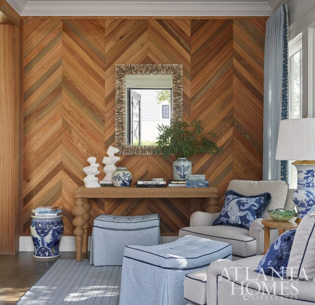 Living room with chevron wood paneled wall, console table, blue and white ginger jars, and