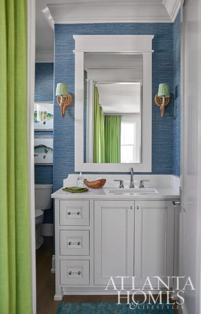 Powder room with blue grasscloth wallpaper, white vanity, and lime green curtains.