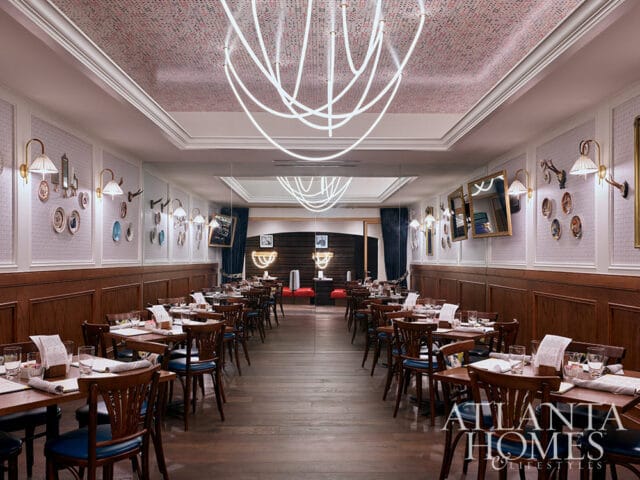 Restaurant dining room with wood paneled walls, white textured wallpaper, and tables set for dining.