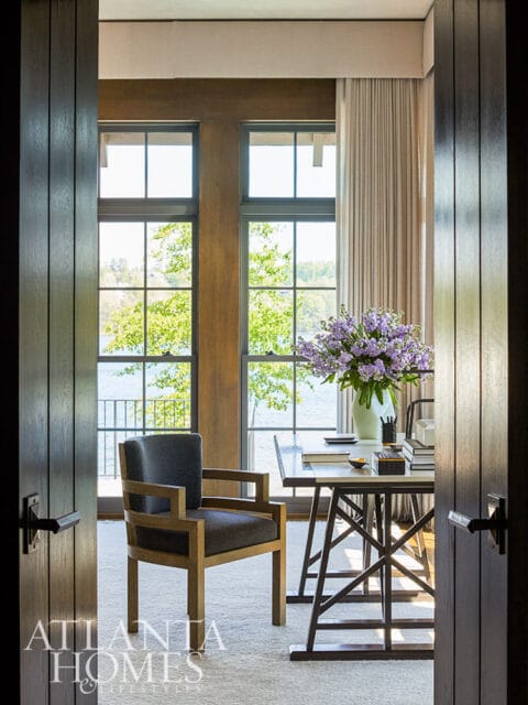 Office with desk, chair, and large windows overlooking water.