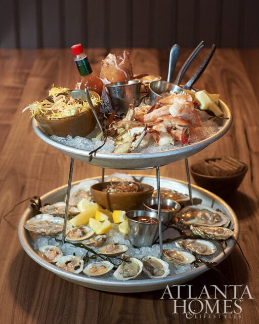 Two-tiered seafood platter with oysters, clams, shrimp, crab, and Tabasco sauce