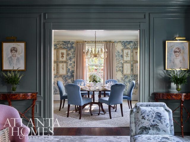 Dining room with blue velvet chairs, floral wallpaper, and a chandelier.