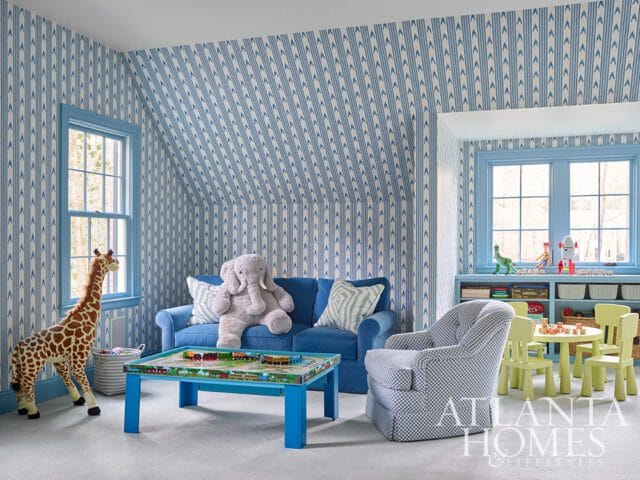 Blue and white striped wallpaper adorns a child's room with a blue sofa, toy giraffe, and checkered
