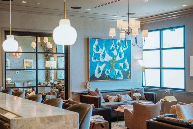 Lounge area with gray walls, abstract art, and modern furniture.