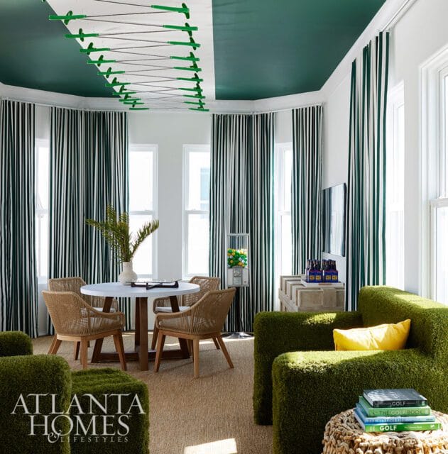 Green and white room with striped curtains, grass-like chairs, and a golf-themed ceiling