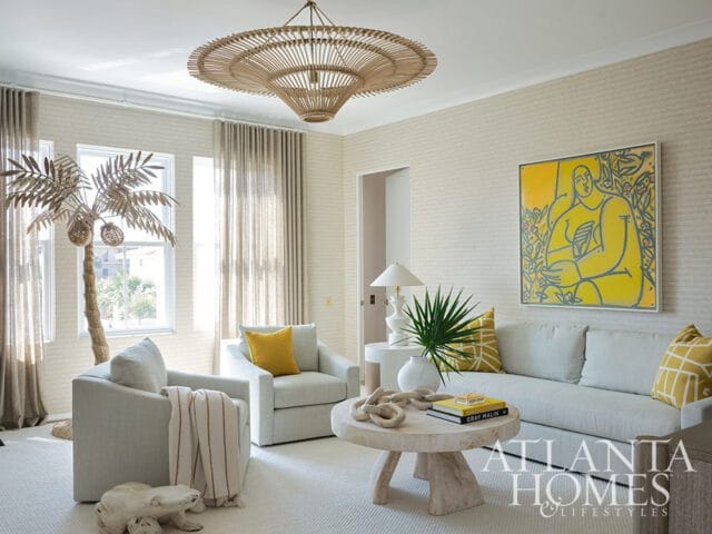 Living room with light gray sofa, chairs, textured wallpaper, yellow art, and rattan chandelier.