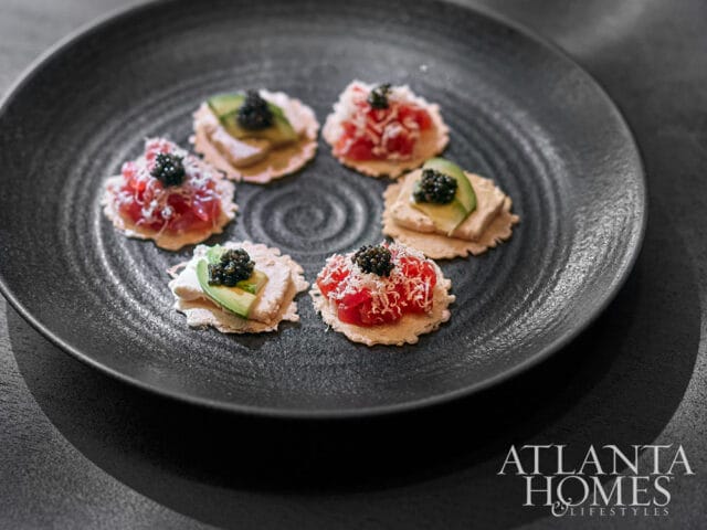 Six appetizers with tuna, avocado, and caviar on a dark plate