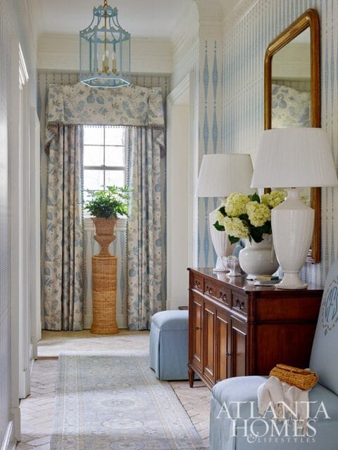 Hallway with blue floral curtains, a blue pagoda lantern, and a wooden console table.