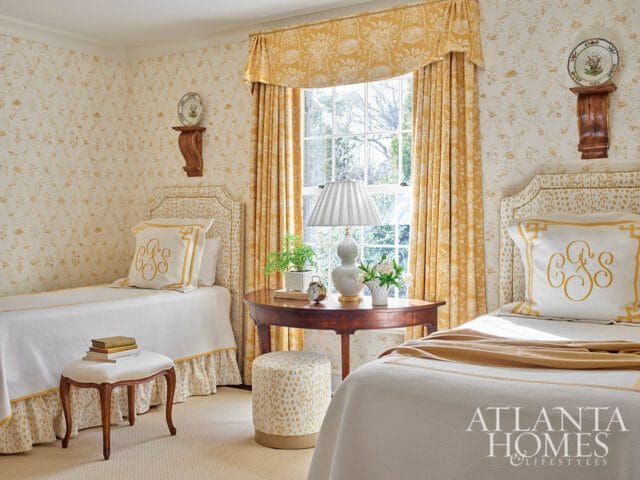 Bedroom with two twin beds, yellow floral wallpaper, and yellow curtains.