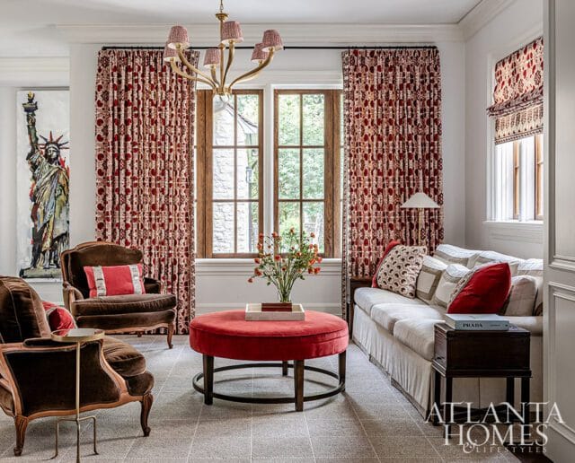 Living room with patterned red curtains, brown velvet chairs, and a white sofa.