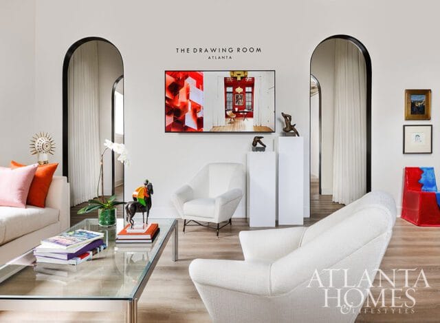 Living room with white chairs, glass coffee table, and arched doorways.
