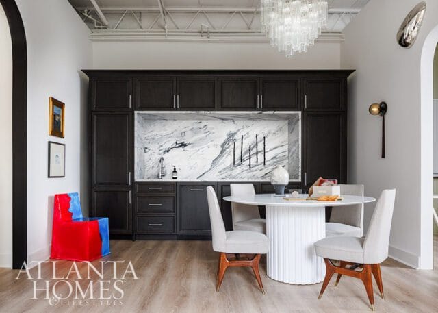 Dark wood cabinetry with marble backsplash, round dining table with chairs, and Atlanta Homes &