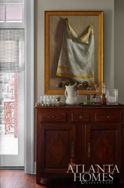 Dark wood cabinet with painting of draped cloth, artichokes, and barware.